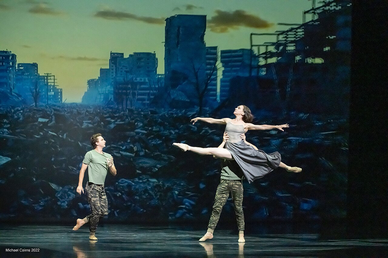 Bailarines de danza contemporánea expresando contacto físico y tensión dramática