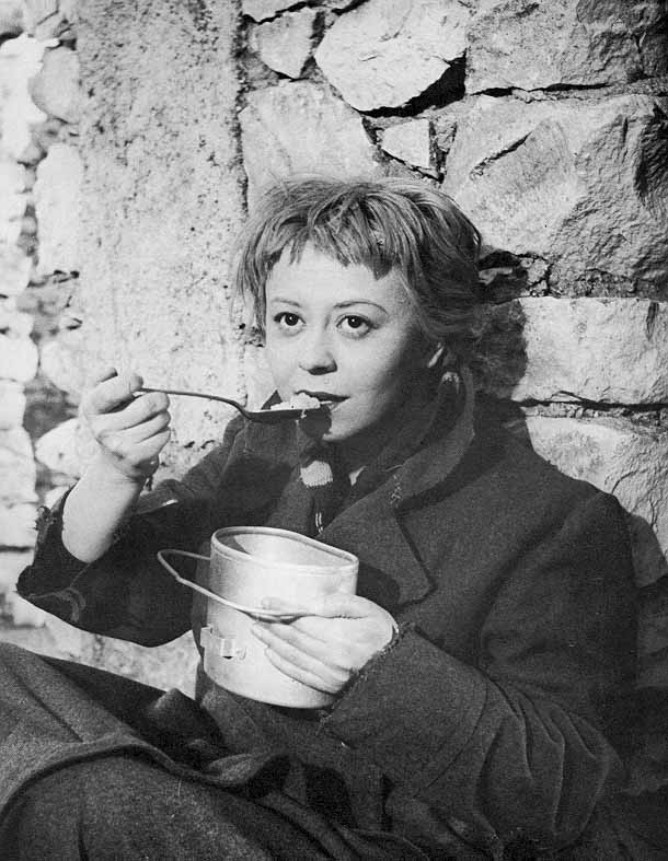 Giulietta Masina vestida de Gelsomina tocando la trompeta en La Strada